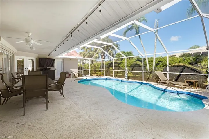 Outdoor pool with a patio, ceiling fan, a lanai, and outdoor dining space