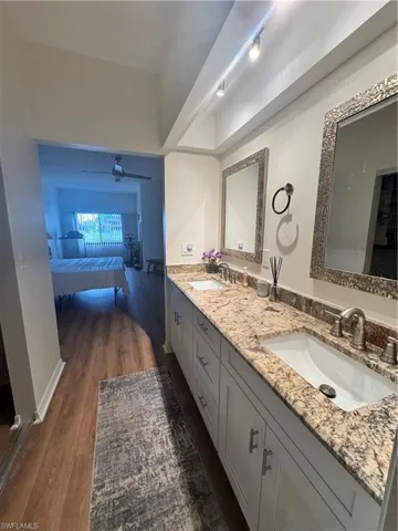 The bathroom features a double vanity with granite countertops, undermount sinks, and framed mirrors