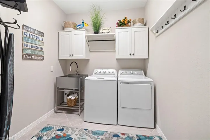 Laundry with cabinets and stainless utility sink