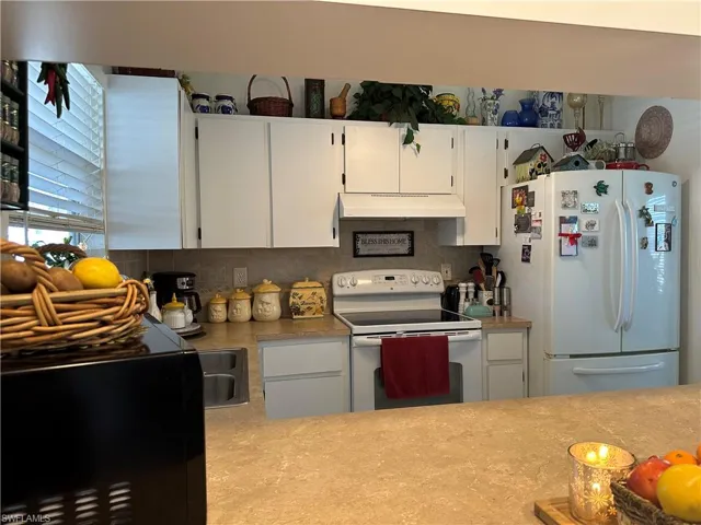 Kitchen with decorative backsplash, and white cabinets