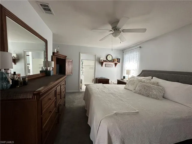 Carpeted bedroom featuring ceiling fan