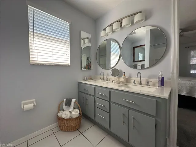 Bathroom featuring tile patterned floors, vanity, and a wealth of natural light