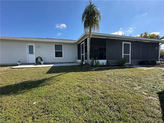 Back of property with a yard, a patio area, and Lanai/Sunroom