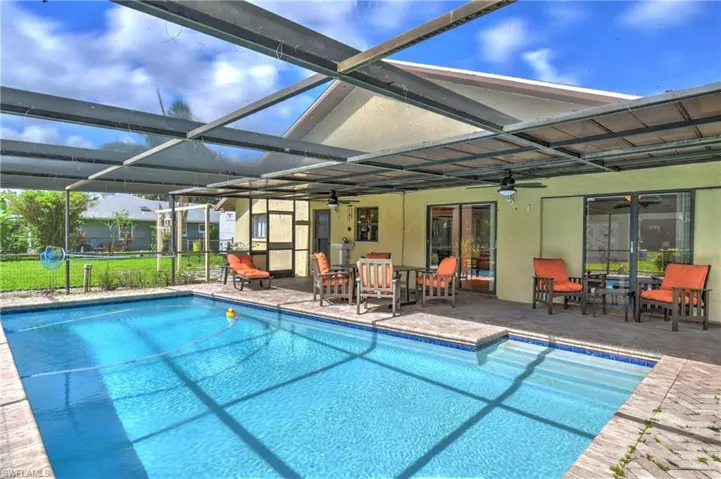 Swimming pool featuring a ceiling fan, a patio area, and glass enclosure