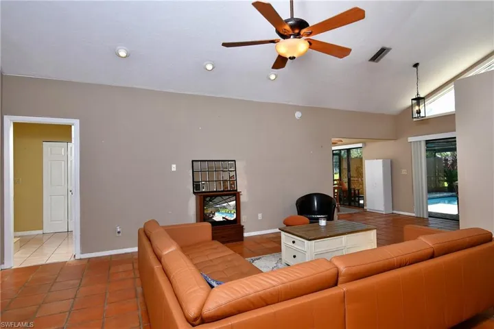Living room featuring light tile patterned floors, a ceiling fan, and high vaulted ceiling