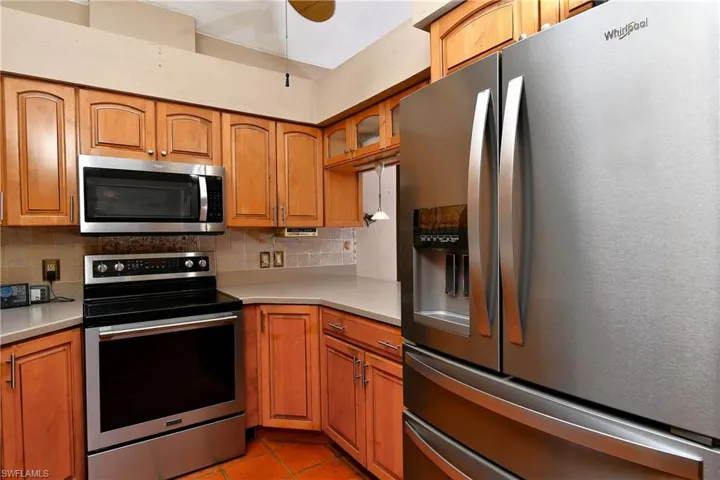 Kitchen featuring stainless steel appliances, backsplash, and brown cabinets