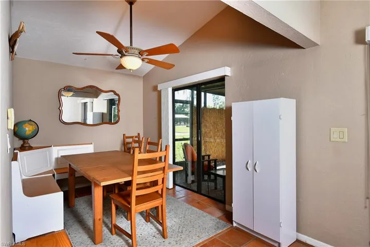 Tiled dining area featuring ceiling fan and lofted ceiling