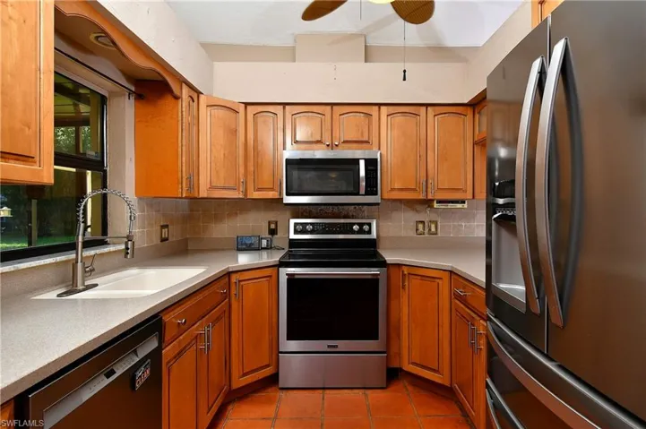 Kitchen with appliances with stainless steel finishes, brown cabinets, and backsplash