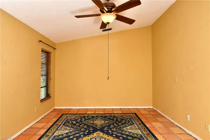 Master bedroom with tile patterned floors and ceiling fan