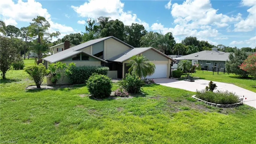 Mid-century inspired home featuring concrete driveway, an attached garage, a front lawn, and stucco siding