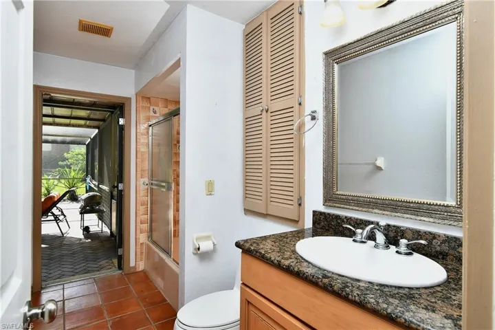 Bathroom with vanity, tile patterned flooring, combined bath / shower with glass door, and a closet