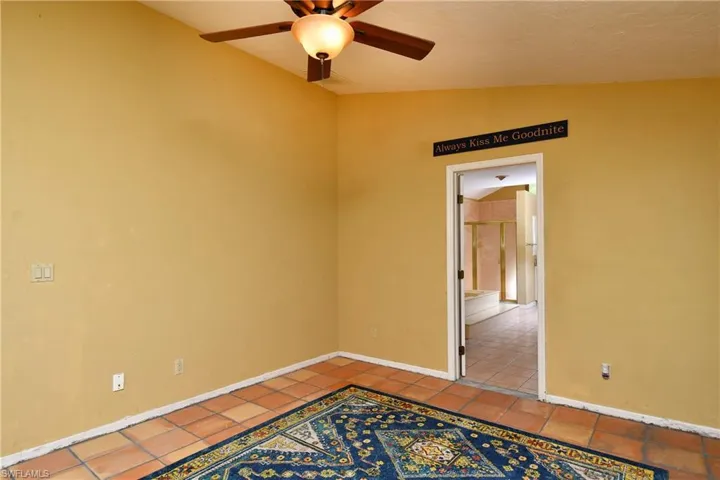 Master bedroom with ceiling fan and baseboards