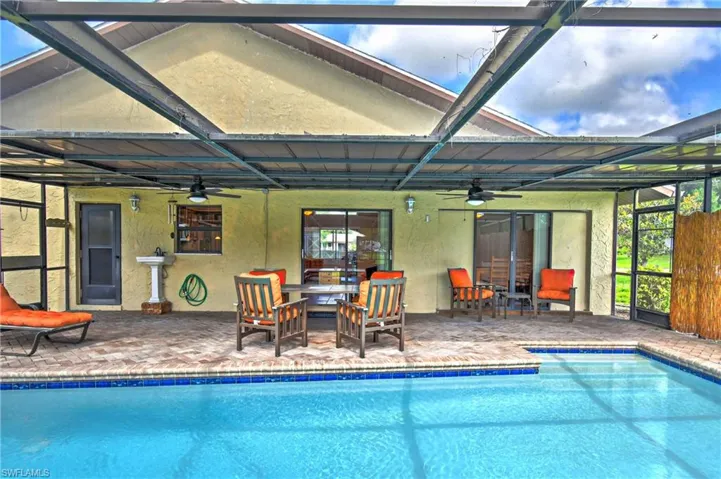 Outdoor pool featuring ceiling fan, a patio area, and a lanai