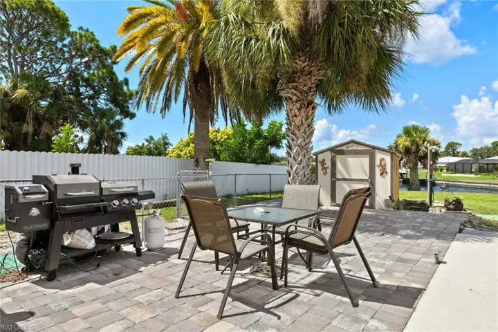 View of patio with grilling area and a storage unit