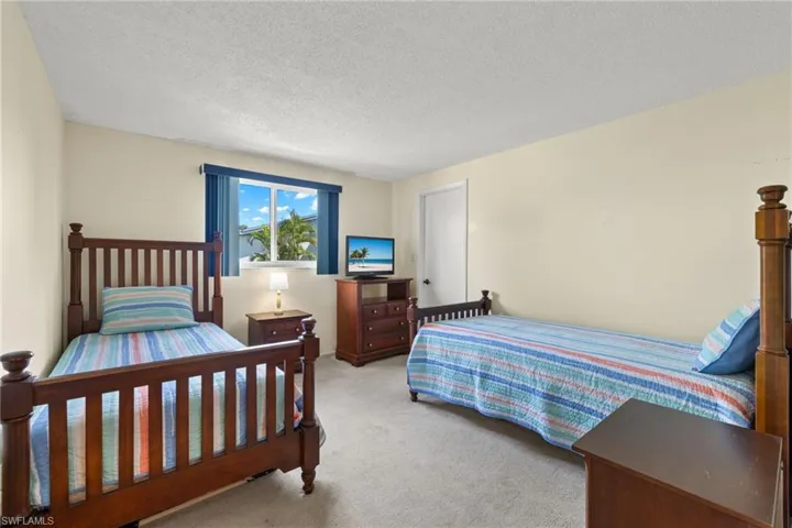 Carpeted guest bedroom featuring a textured ceiling