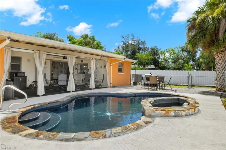 View of pool with a patio and an in ground hot tub