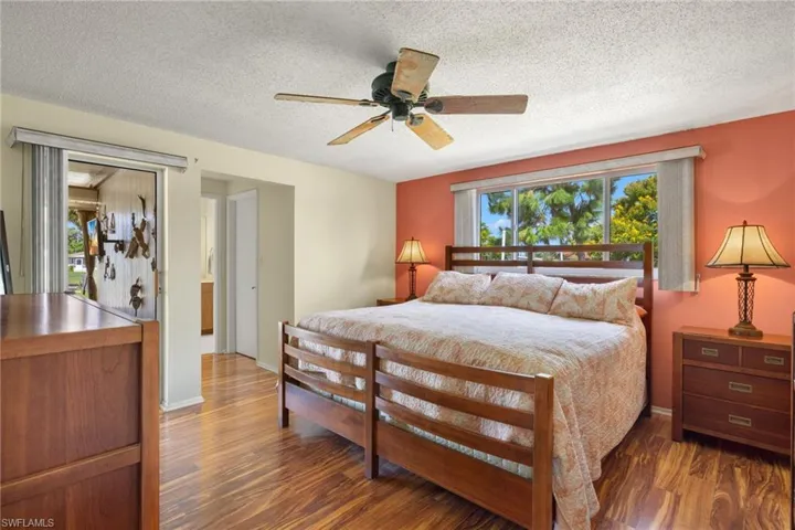 Primary Bedroom featuring a textured ceiling, dark hardwood / wood-style flooring, and ceiling fan
