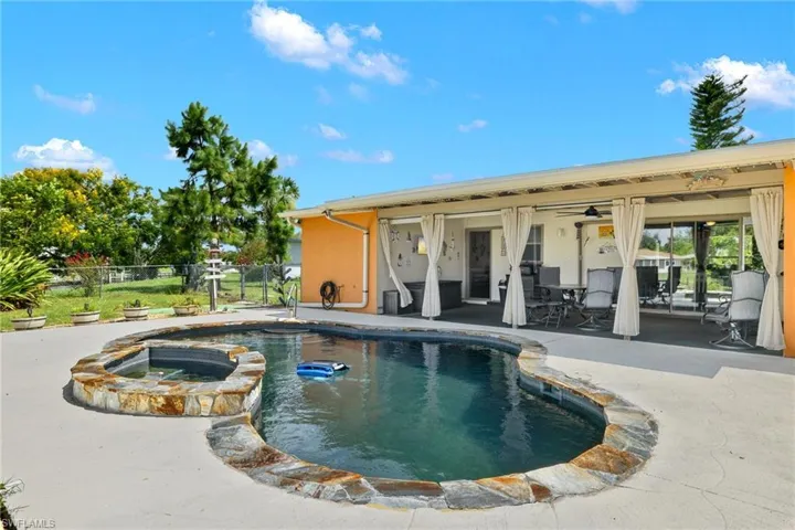 View of pool featuring ceiling fan, a patio, and an in ground hot tub