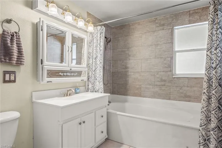 Full bathroom featuring vanity, shower / bathtub combination, tile patterned flooring