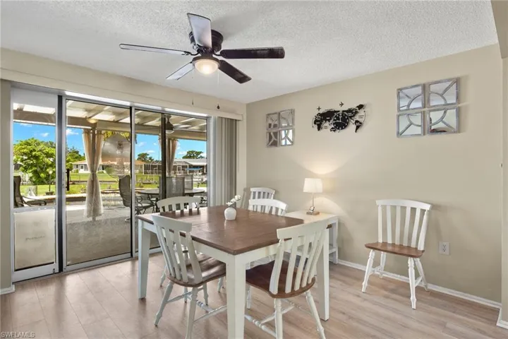 Dining area featuring ceiling fan, light hardwood / wood-style flooring, and a textured ceiling