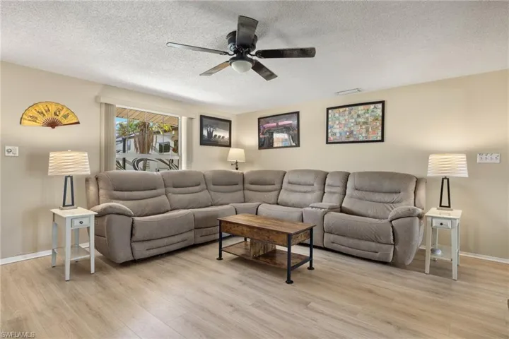 Living room with ceiling fan, light wood-type flooring
