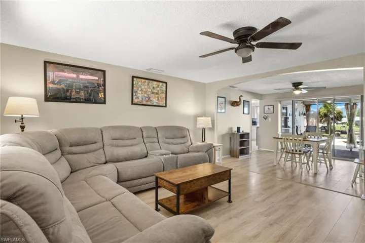 Living room with ceiling fan, light hardwood / wood-style flooring
