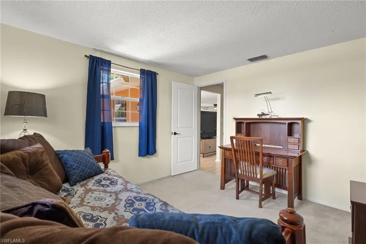 Living room with a textured ceiling and light carpet