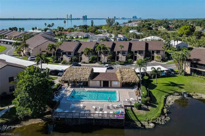 Aerial perspective of suburban area with a large body of water and a pool