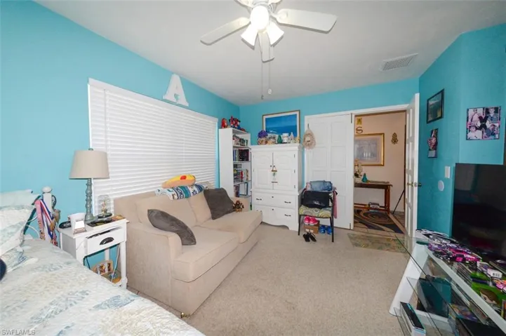 Bedroom featuring a ceiling fan and carpet