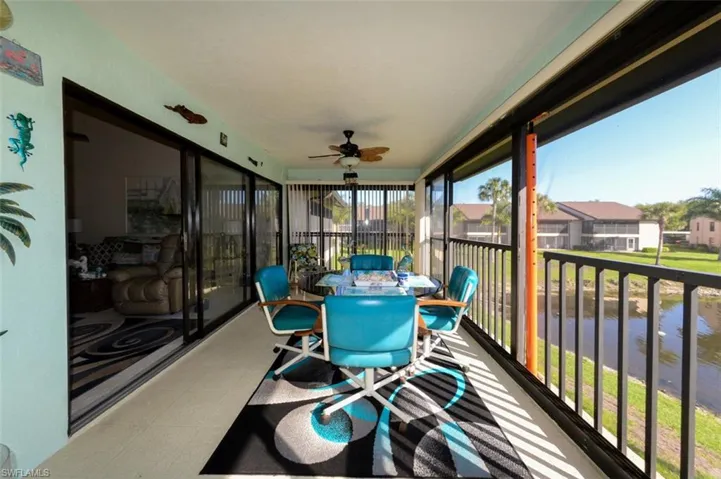 Sunroom / solarium featuring tile patterned floors and a water view