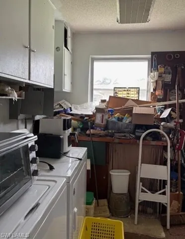 Laundry room featuring a textured ceiling and independent washer and dryer