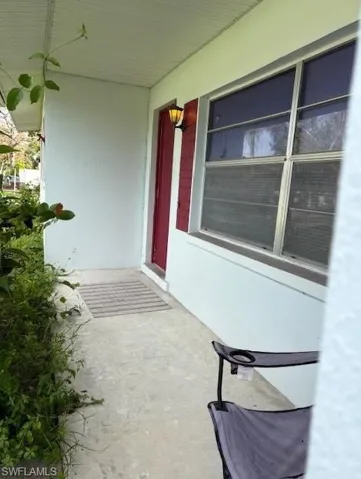Doorway to property with front covered porch and stucco siding