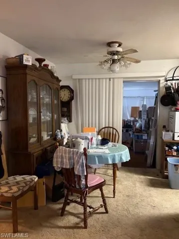 Carpeted dining space with a ceiling fan