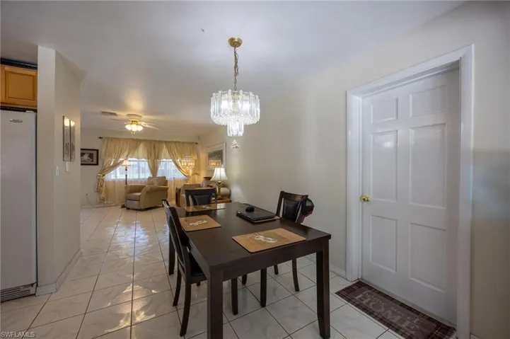 Dining area with a ceiling fan, a chandelier, and an office area