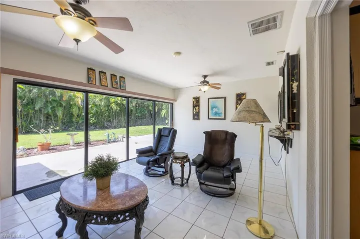 Living area with a ceiling fan and light tile patterned flooring