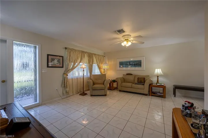 Living area featuring plenty of natural light, ceiling fan, and light tile patterned floors