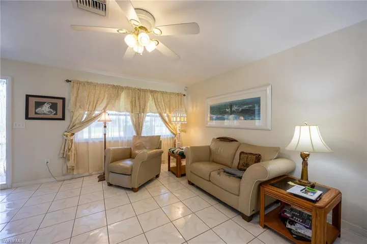 Living area with ceiling fan and baseboards