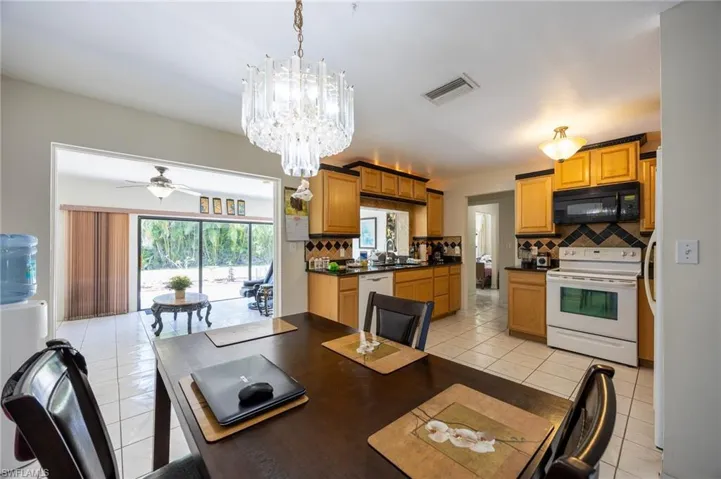Dining room with a chandelier, ceiling fan, and light tile patterned floors