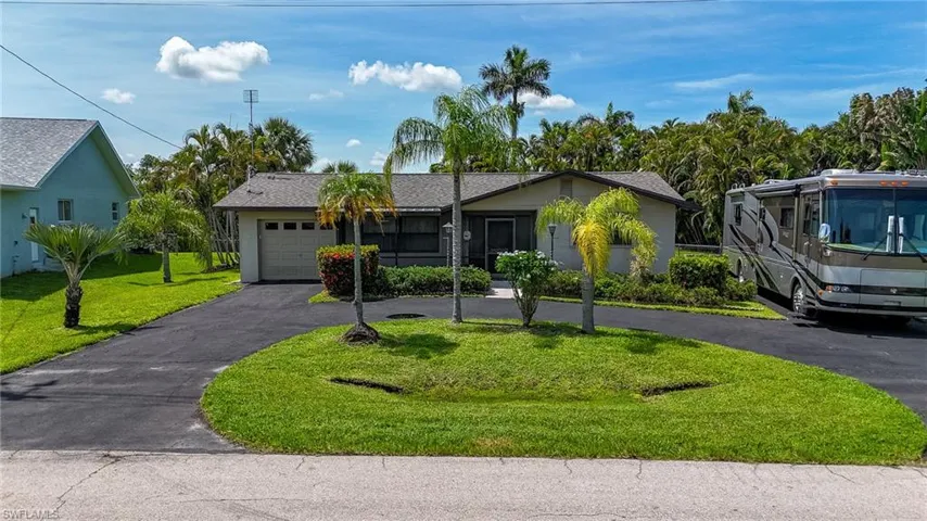 View of front of home with driveway, an attached garage, a front yard, and stucco siding