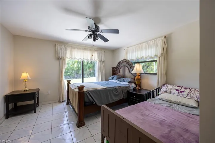 Bedroom with light marble finish floors and ceiling fan