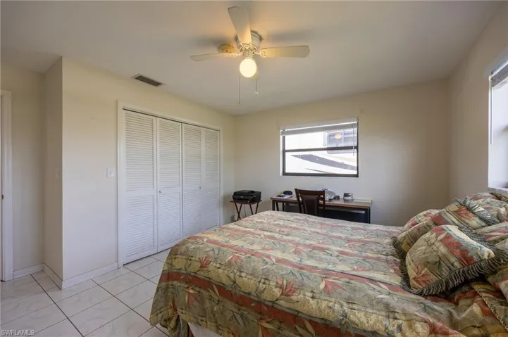 Bedroom with multiple windows, a closet, and a ceiling fan