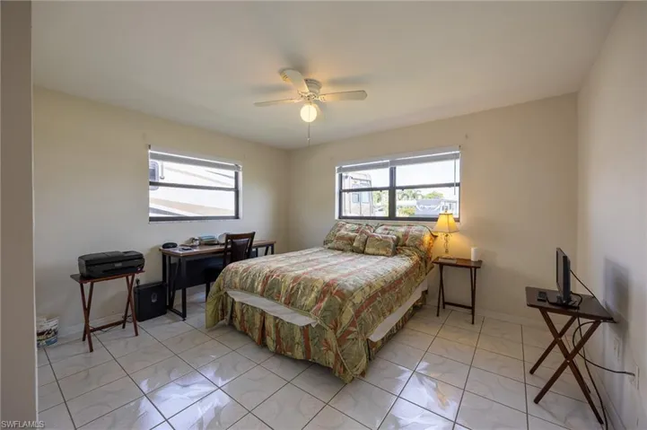 Bedroom with multiple windows and ceiling fan