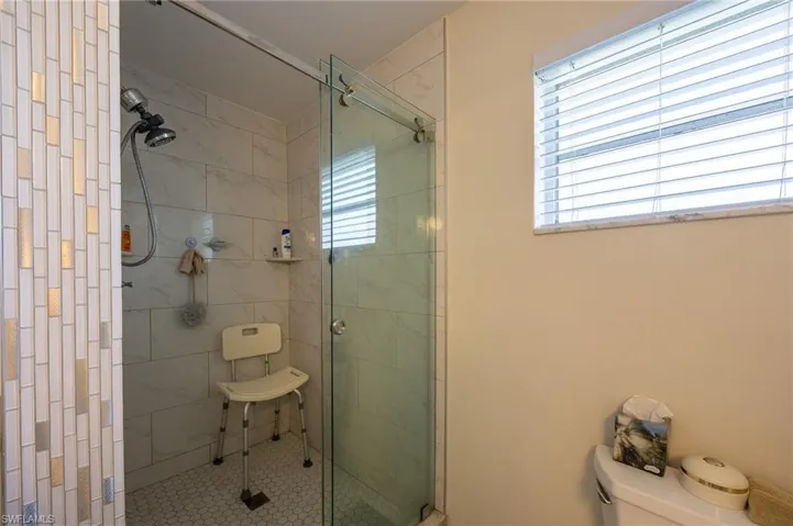 Bathroom with a stall shower and tile patterned flooring