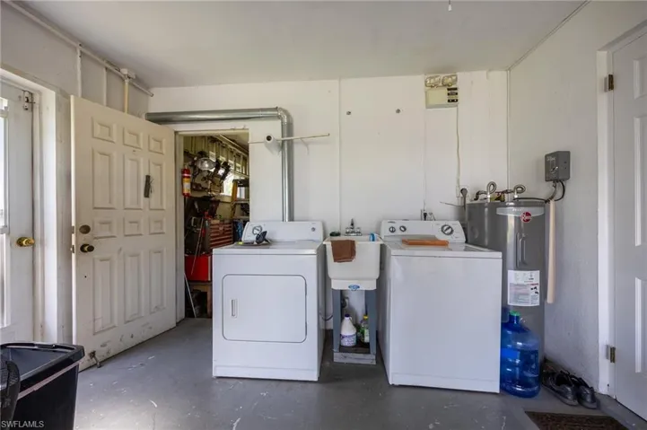 Laundry area featuring washing machine and clothes dryer and water heater