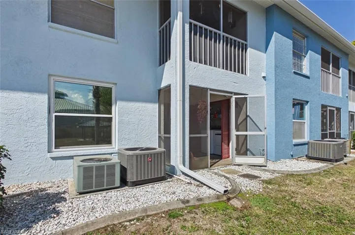 Rear view of property with stucco siding, a sunroom, and a balcony