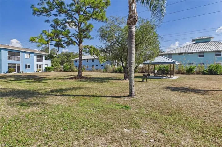 View of grassy yard with a gazebo and a patio area