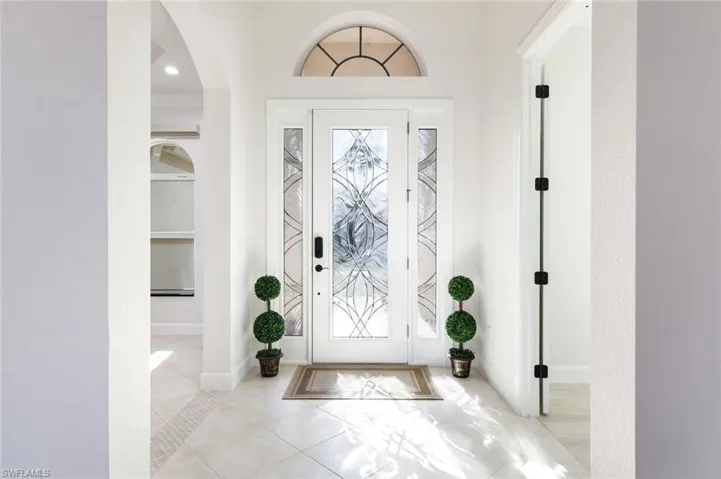 Plank Tiled entryway with tall baseboards and arched walkways