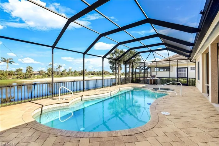 Outdoor pool with a lanai, a patio, and a water view