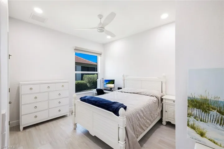 Guest Bedroom with light plank tile floors, recessed lighting, and a ceiling fan