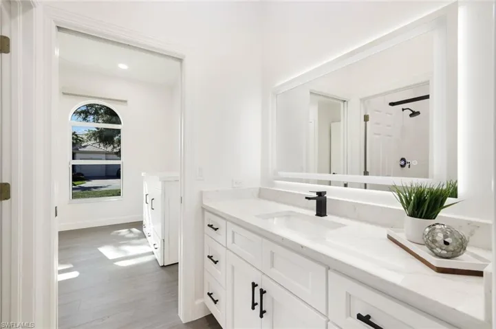Full bath with walk in shower, plank tile floors, and vanity